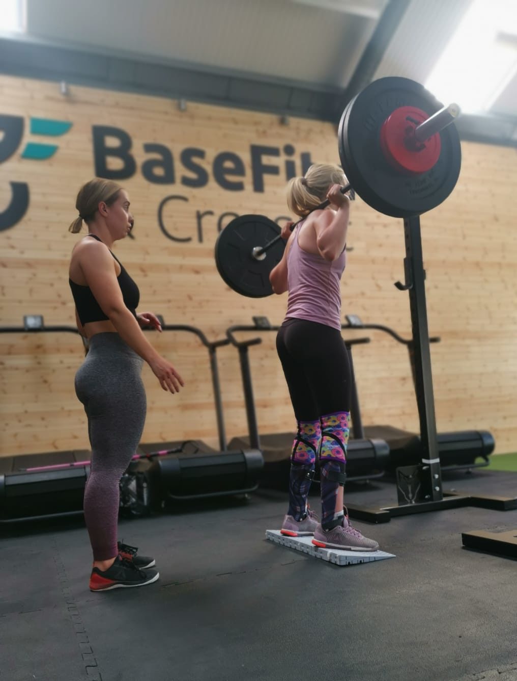 image of female gym members in base unit 03 doing back squats