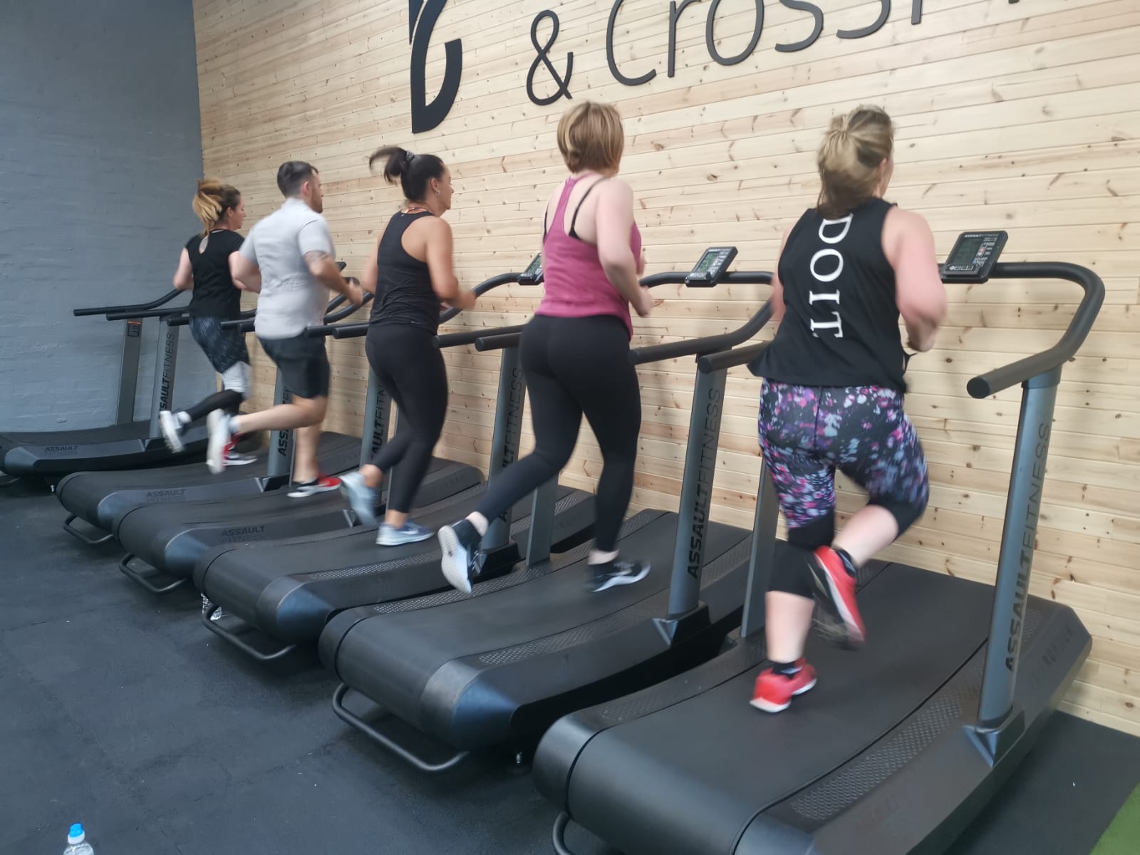 image of a class of gym members using the assault fitness running machines